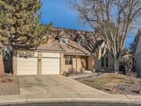 Charming two-story brick home with a three-car garage and mature trees in a desirable neighborhood at 6141 W Evans Pl, Lakewood, CO 80227