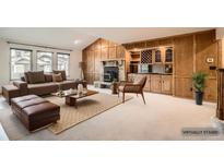 Staged living room with a wooden fireplace and built-in bar area at 6141 W Evans Pl, Lakewood, CO 80227