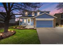 Charming two-story home with a well-manicured lawn, stone accents, and a cozy front porch at 11753 Elizabeth Cir, Thornton, CO 80233