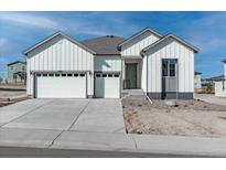 Charming home with white siding, gray trim, and a spacious two-car garage offering modern curb appeal at 13805 Emerald Lake St, Parker, CO 80138