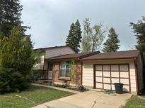Charming home with a brick facade, a well-manicured lawn, and an attached garage at 9260 Cody Ln, Broomfield, CO 80021