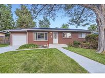 Charming single-story brick home with a well-manicured lawn and walkway at 2982 S Vrain St, Denver, CO 80236
