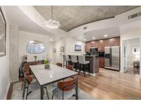 Open concept kitchen and dining area with modern lighting and stainless steel appliances at 1700 Bassett St # 1418, Denver, CO 80202