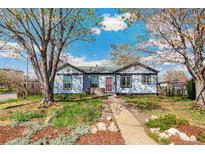 Charming single-story home with a tidy front yard and a inviting walkway under mature trees at 4401 Quieto Ct, Denver, CO 80211