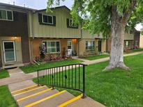 Charming townhome featuring a landscaped yard and steps leading to the inviting front door at 604 S Xenon Ct, Lakewood, CO 80228