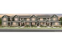 Modern townhome featuring stone accents, sleek lines, and a welcoming entrance at 17115 W 91St Ln, Arvada, CO 80007