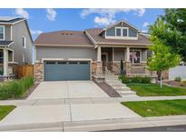 Charming home featuring a two-car garage, stone accents, and a cozy front porch with beautiful landscaping at 17409 Springfield Dr, Parker, CO 80134