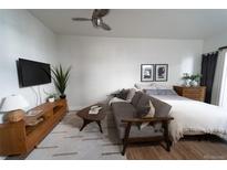 Bright and airy bedroom featuring a seating area, ceiling fan, and a comfortable bed with stylish decor at 215 E 11Th Ave # A5, Denver, CO 80203