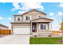 Charming two-story home featuring a covered porch, two-car garage, and well-manicured lawn at 941 Sarah Ave, Fort Lupton, CO 80621