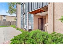 Charming condo exterior with muted tones and landscaping and a covered entry and a shared bench at 865 S Quebec St # 101B, Denver, CO 80247