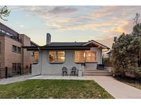Charming single-story home featuring a well-manicured lawn and inviting front patio at 561 Cook St, Denver, CO 80206