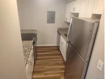 Cozy kitchen featuring granite counters, stainless steel appliances, and wood flooring at 12148 Melody Dr # 108, Denver, CO 80234