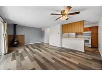 Inviting living room features a decorative fireplace, wood floors, and easy access to the kitchen and outdoor space at 2150 S Vaughn Way # 302D, Aurora, CO 80014