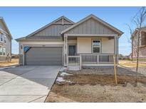 Charming single-Gathering home with a covered porch, gray siding, and a two-car garage at 16622 E 109Th Ave, Commerce City, CO 80022