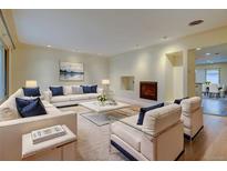 Bright living room featuring modern white sofas, a fireplace, and a seamless open floor plan at 1275 Fairfax St, Denver, CO 80220
