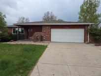 Charming brick home with a well-manicured lawn and a spacious two-car garage at 13487 Antares Dr, Littleton, CO 80124