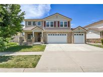 Charming two-story home featuring a three car garage, landscaped lawn, and brick accents, with great curb appeal at 5131 Netherland St, Denver, CO 80249