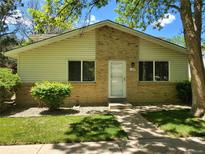 Charming single-story home with a brick facade, well-maintained landscaping, and inviting entryway at 9105 E Lehigh Ave # 105, Denver, CO 80237