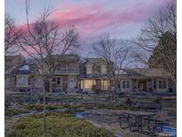 Evening view of townhouses with a park-like setting and picnic tables at 7725 S Cove Cir, Centennial, CO 80122