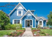 Charming blue two-story home with white trim, manicured landscaping and inviting entrance at 3171 Fulton St, Denver, CO 80238