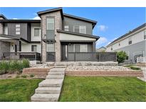 Modern two-story home featuring stone accents, a front porch, and well-maintained landscaping at 2054 S Upham Way, Denver, CO 80227