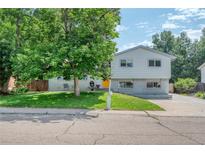 Traditional home with well-kept lawn, mature shade tree, painted brick, and welcoming curb appeal at 1346 S Grant St, Longmont, CO 80501