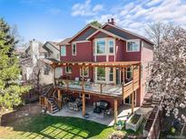 Two story home with a spacious deck, outdoor seating, and backyard at 9145 Sugarstone Cir, Highlands Ranch, CO 80130