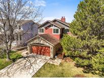 Charming two-story home features a stone-clad garage and a well-manicured lawn at 9145 Sugarstone Cir, Highlands Ranch, CO 80130