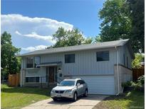 Charming two-story home with attached garage and manicured front yard with car parked in driveway at 1477 S Wright Ct, Lakewood, CO 80228