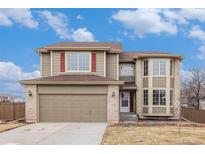 Charming two-story home features a brick-accented facade, attached garage, and a well-manicured front yard at 6876 Edgewood Way, Highlands Ranch, CO 80130