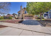 Charming two-story home with a well-manicured front yard and a spacious two car garage at 4560 Flanders Way, Denver, CO 80249