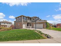 Charming two-story home featuring a well-manicured lawn and a three car garage at 26530 E Euclid Pl, Aurora, CO 80016