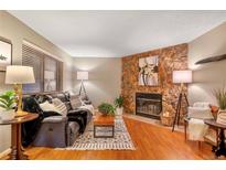 Comfortable living room featuring a stone fireplace and plush black leather seating at 9411 W 89Th Cir, Westminster, CO 80021