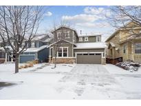 Two-story house with a large driveway, snow-covered lawn, and neutral color scheme at 10251 Rifle St, Commerce City, CO 80022