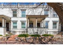 Charming two-story white brick home featuring a covered front porch and well-maintained landscaping at 325 E 7Th Ave, Denver, CO 80203
