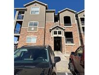 Attractive condo building features a stone facade, covered entryway, and a private balcony at 1425 Blue Sky Cir # 15-204, Erie, CO 80516