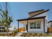 Contemporary home featuring a covered porch, modern design, and professionally landscaped front yard at 9651 E 61St Pl, Denver, CO 80238