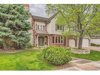 Charming two-story home with a well-maintained lawn and brick and stone accents at 5390 S Geneva St, Englewood, CO 80111