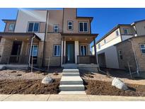 Two-story townhome with modern facade, landscaping, and a covered porch at 6589 N Netherland St, Aurora, CO 80019