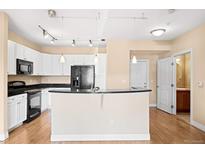 Bright kitchen features white cabinetry, granite countertops, and stainless-steel appliances at 9019 E Panorama Cir # D211, Centennial, CO 80112
