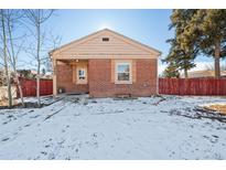 Brick ranch home with snow-covered yard at 3998 Haddon Rd, Denver, CO 80205