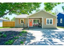 Charming single-story home with a welcoming front porch, orange door, and well-maintained landscaping at 5610 Brentwood St, Arvada, CO 80002