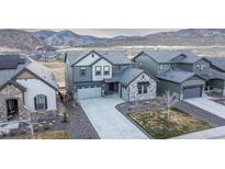 Beautiful two-story home featuring a stone facade and three-car garage, backing up to scenic mountains at 3137 S Quaker St, Morrison, CO 80465