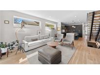 Bright living room with a comfortable sofa, modern furniture, and an open floor plan to the kitchen at 4426 Utica St, Denver, CO 80212