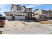 Two-story home with a three-car garage and stone accents, complemented by a well-maintained front yard at 26818 E 1St Pl, Aurora, CO 80018