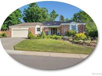 Charming one-story brick home featuring a well-manicured lawn and an attached two-car garage at 6844 S Detroit Cir, Centennial, CO 80122