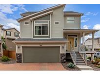 Inviting two-story home with a two-car garage, appealing architectural details, and a welcoming front porch at 10102 Yampa Ct, Commerce City, CO 80022