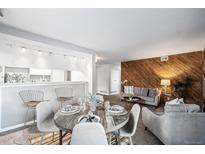 Inviting living space featuring wood accent wall, modern seating, and a stylish dining area with bar seating at 12470 E Cornell Ave # 104, Aurora, CO 80014