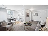 Bright living room features a dining area, bar seating, and modern decor for a comfortable living space at 12470 E Cornell Ave # 104, Aurora, CO 80014