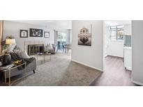 Cozy living room featuring a fireplace, plush seating, and sliding glass doors leading to outdoor space at 12470 E Cornell Ave # 104, Aurora, CO 80014